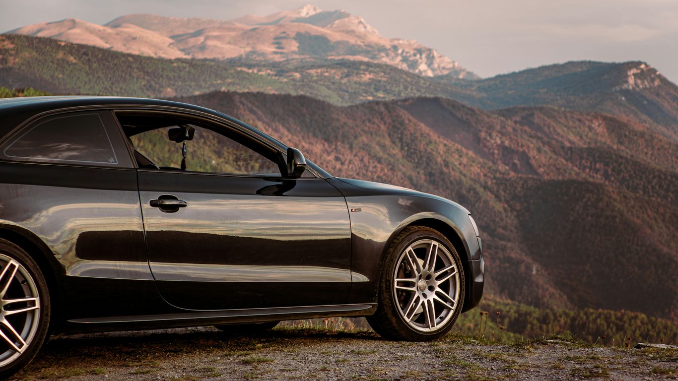 Black car parked on a mountain overlook.