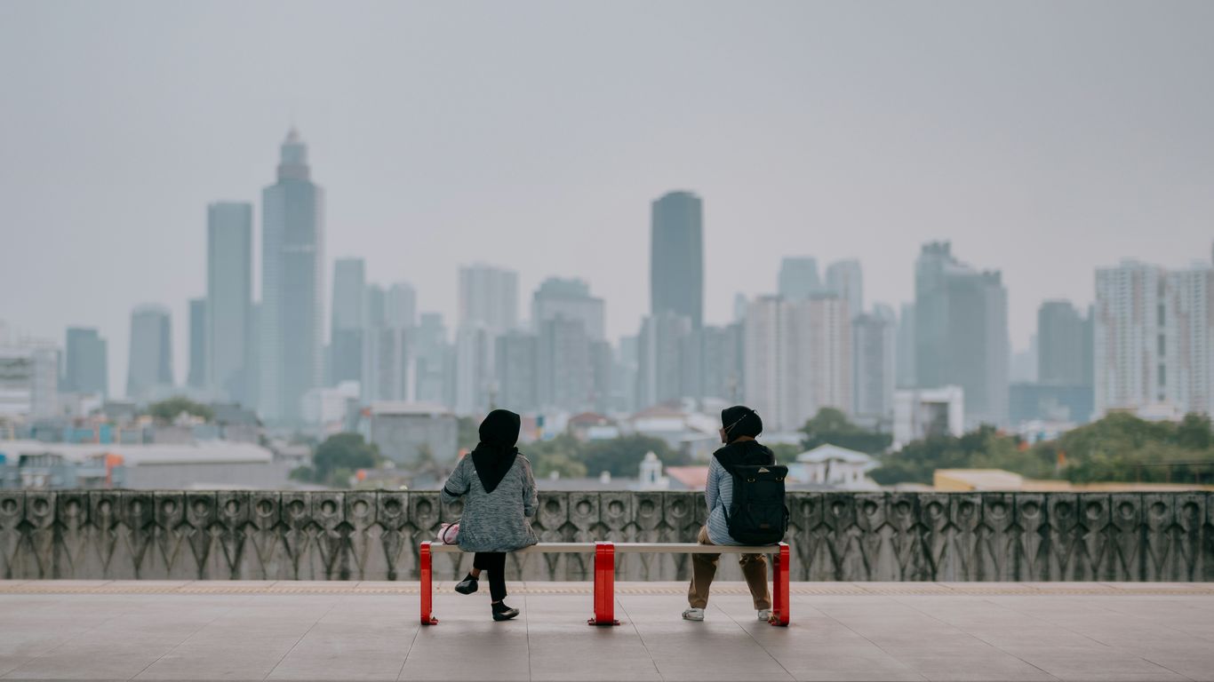 A couple of people standing on top of a bridge