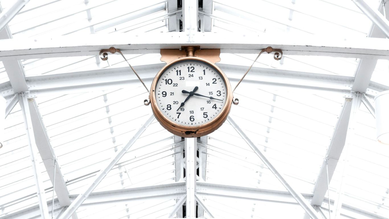 round gold and white analog clock reading at 7:10