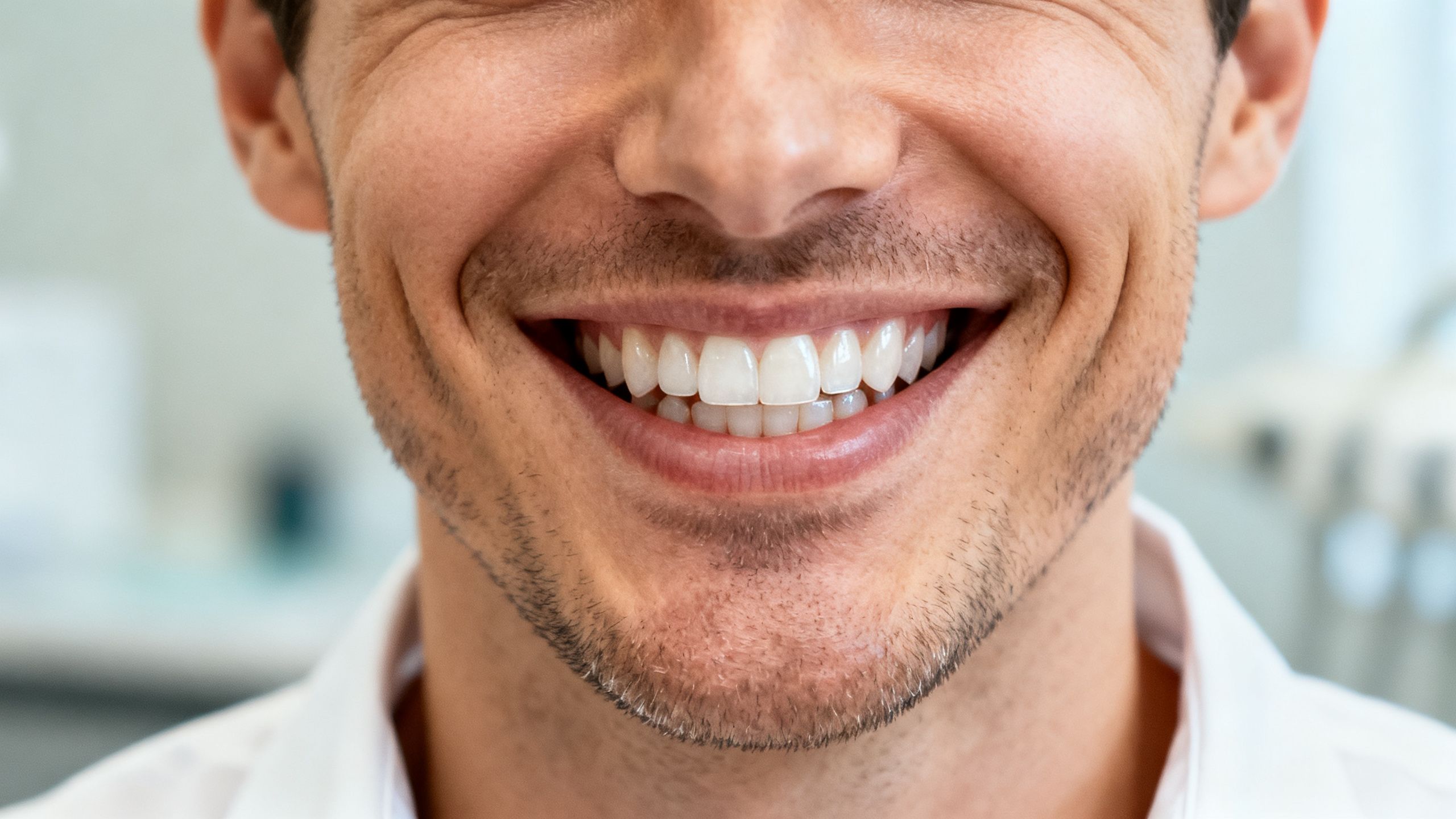 A smiling person with a perfect, natural-looking set of teeth, showcasing the final result of dental implants.