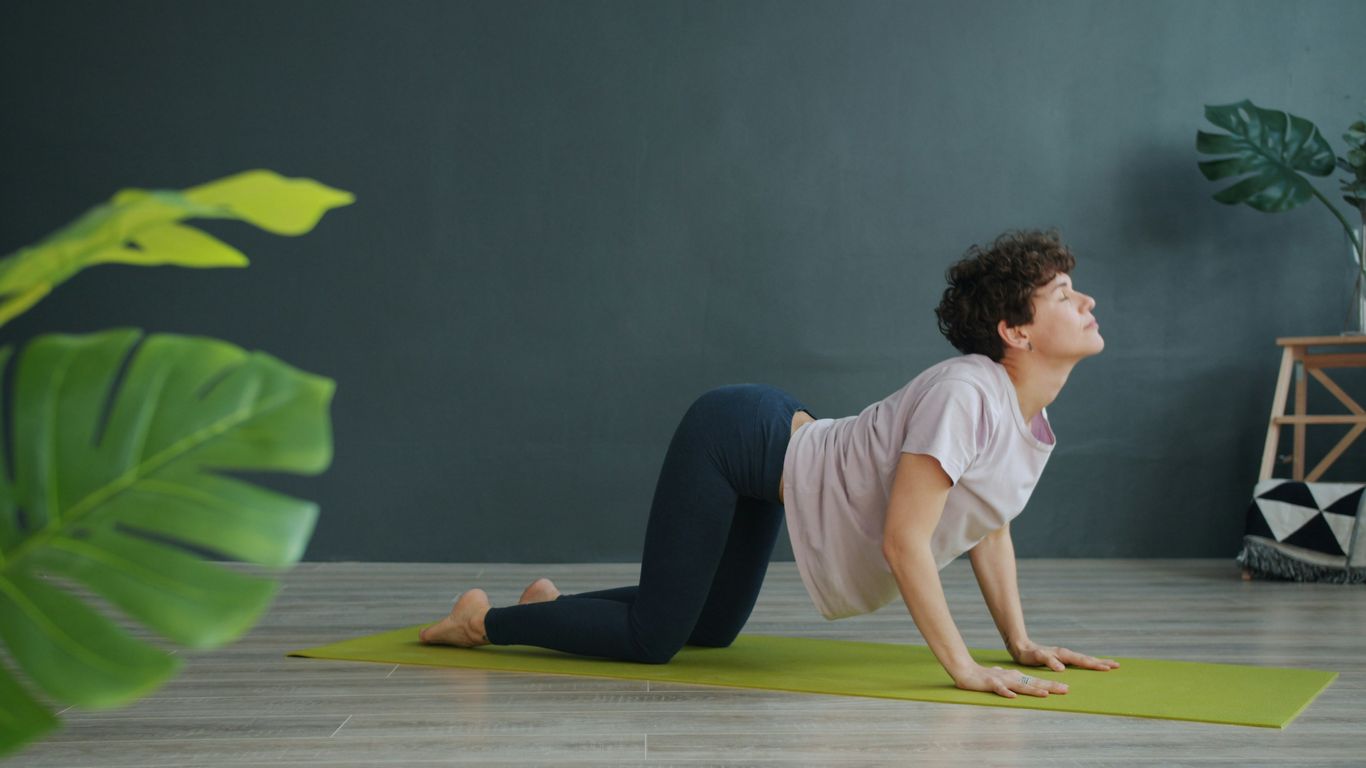 Woman in yoga pose on mat indoors