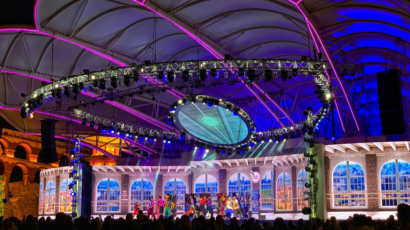 people standing in front of blue and yellow lighted building