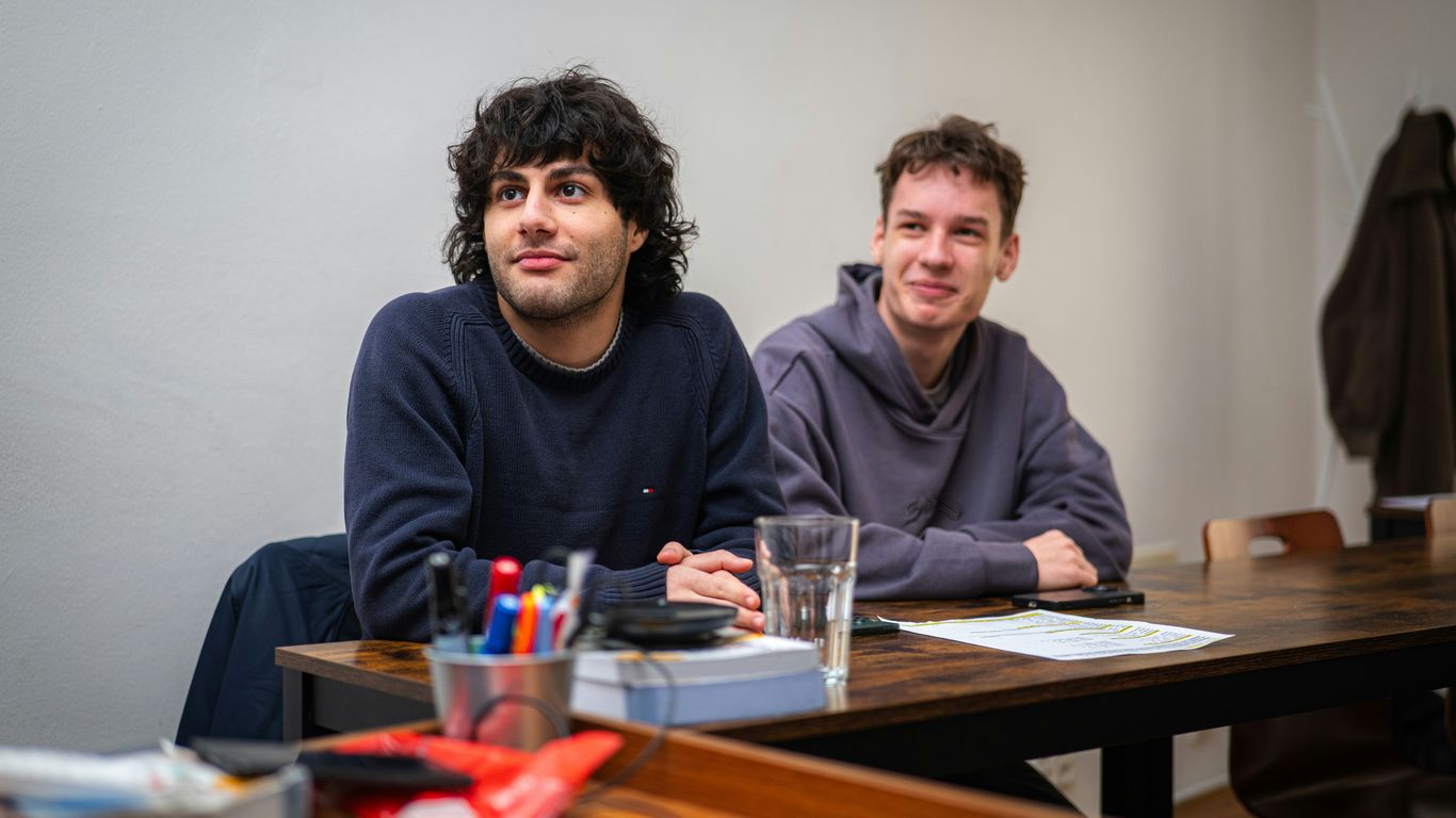 Two men sitting at a table indoors.