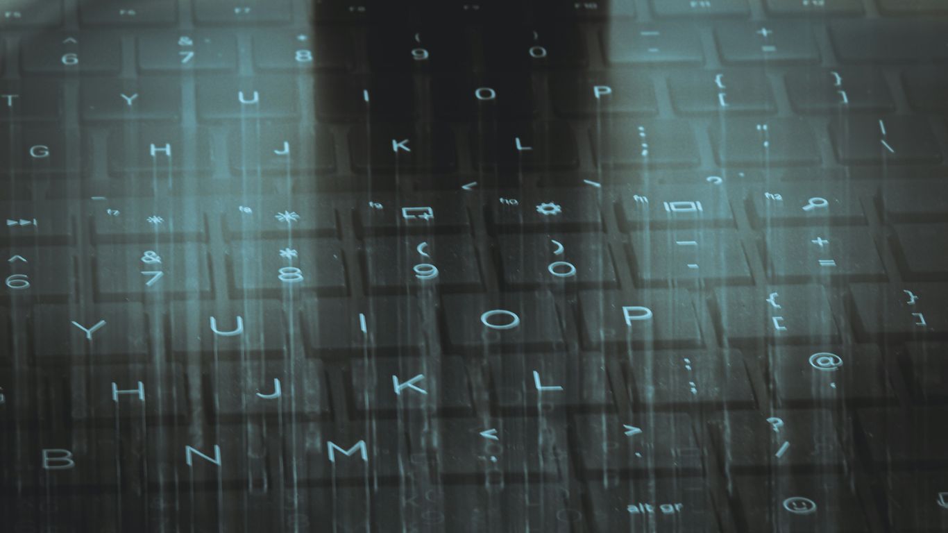 A computer keyboard with a sky background