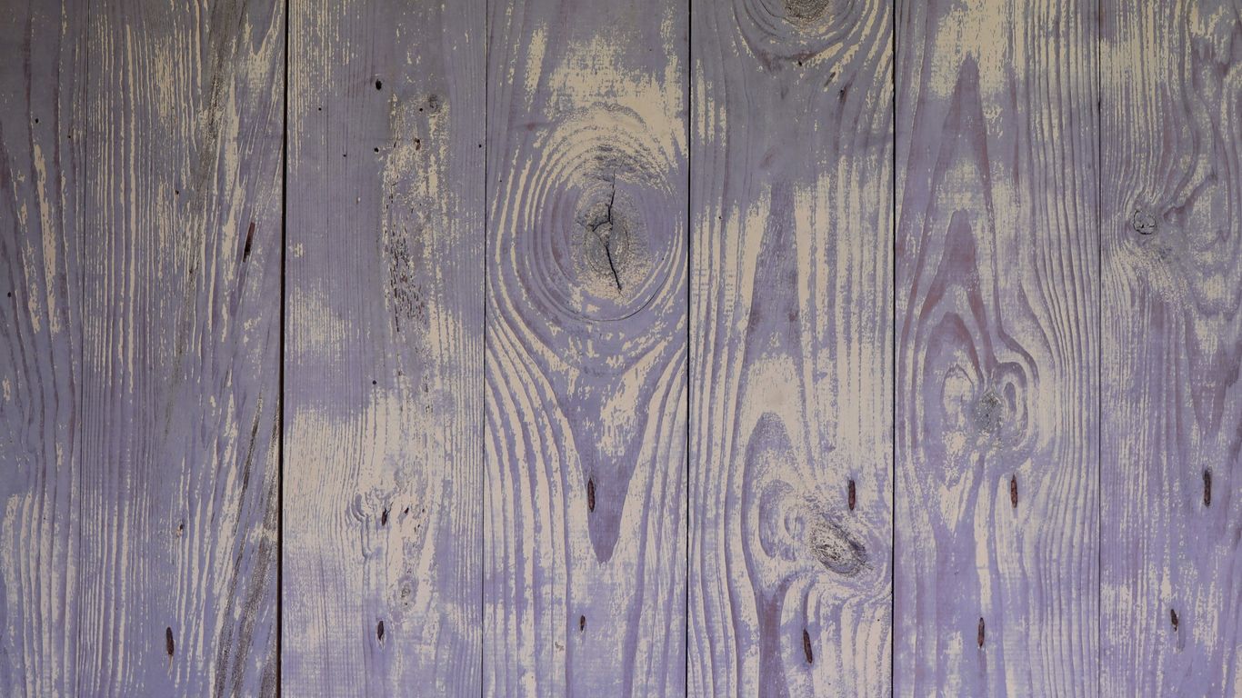 a close up of a wooden wall with purple paint