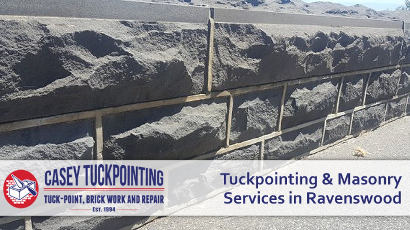 A stone wall with tuckpointing and masonry services advertised.