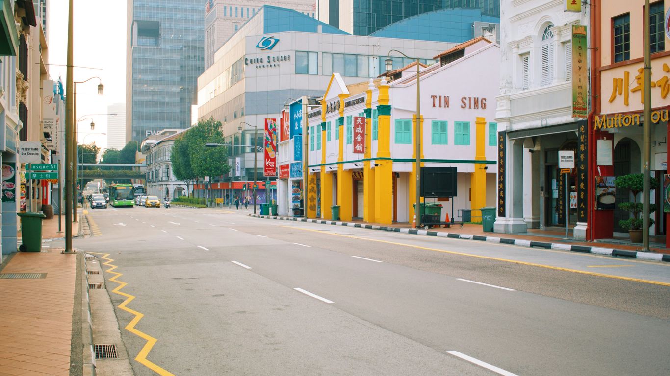 Quiet Singapore street under wartime clouds