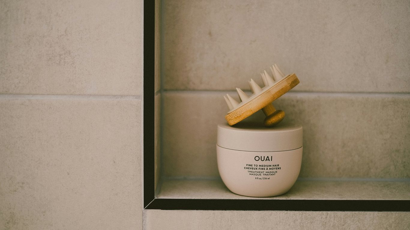 A skincare product and brush are on a shelf.