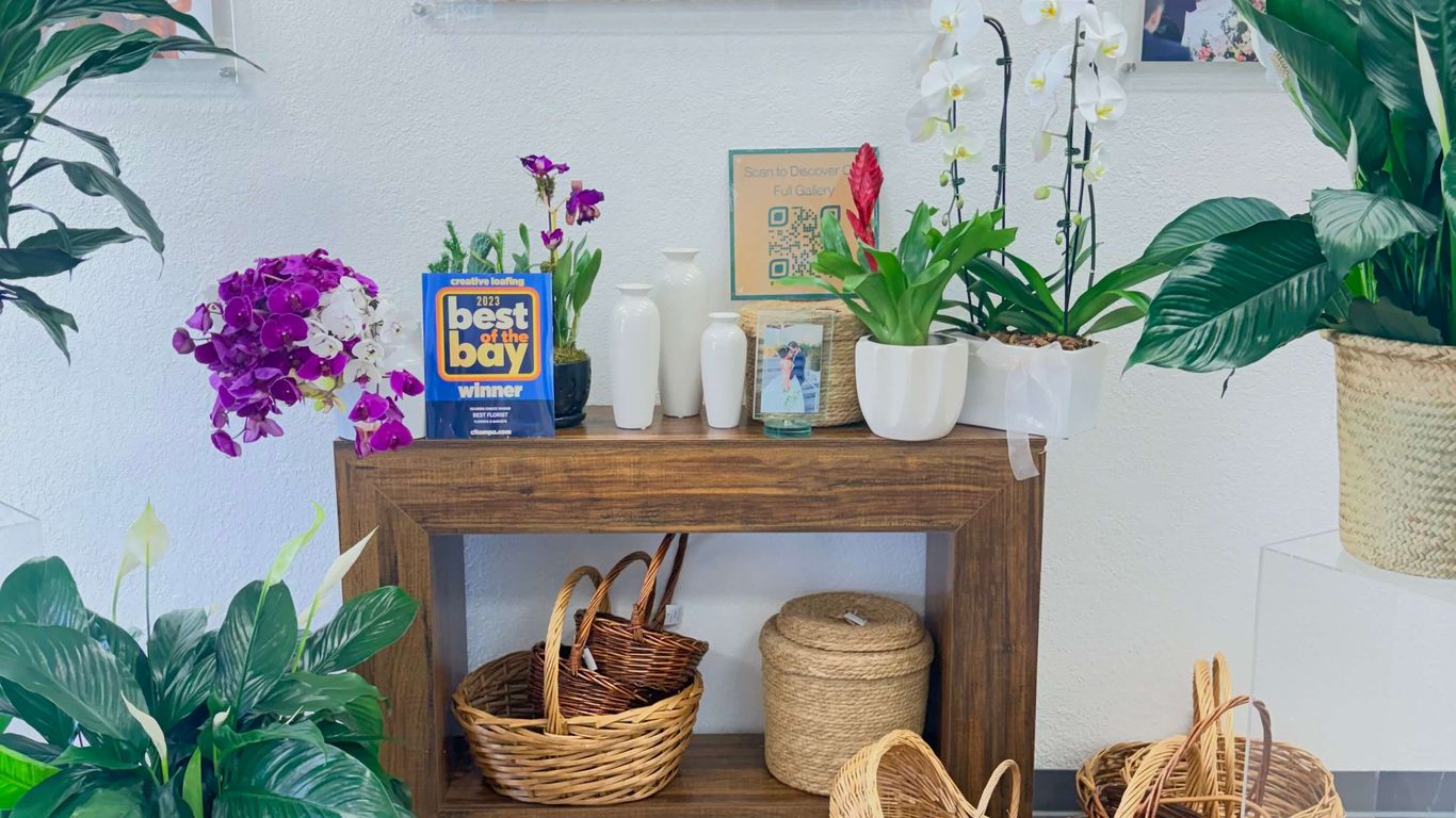 Wedding photos and floral arrangements displayed in a store.