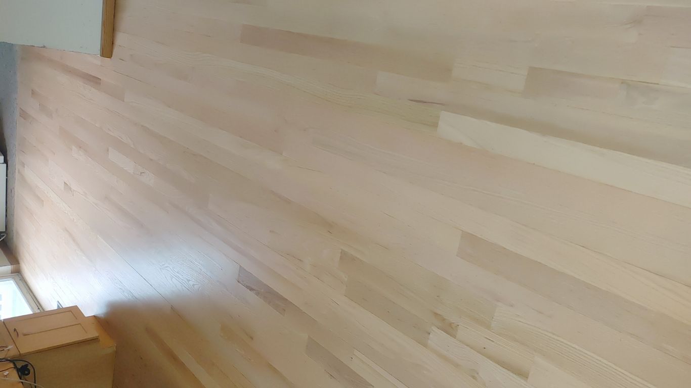 Light-colored hardwood floor in a spacious, well-lit room.