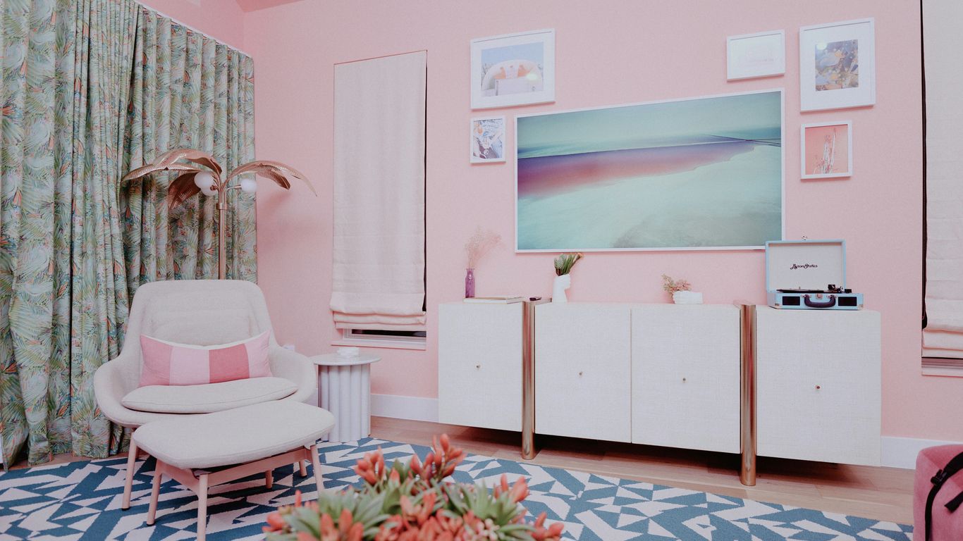 a living room with pink walls and a white chair