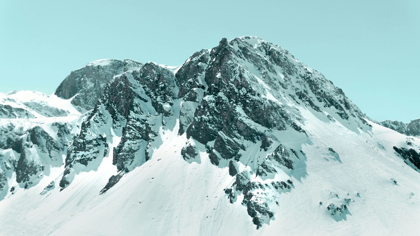 Snow-capped mountain peak against a clear blue sky, representing resilience and stability, relevant to system performance during peak seasons.