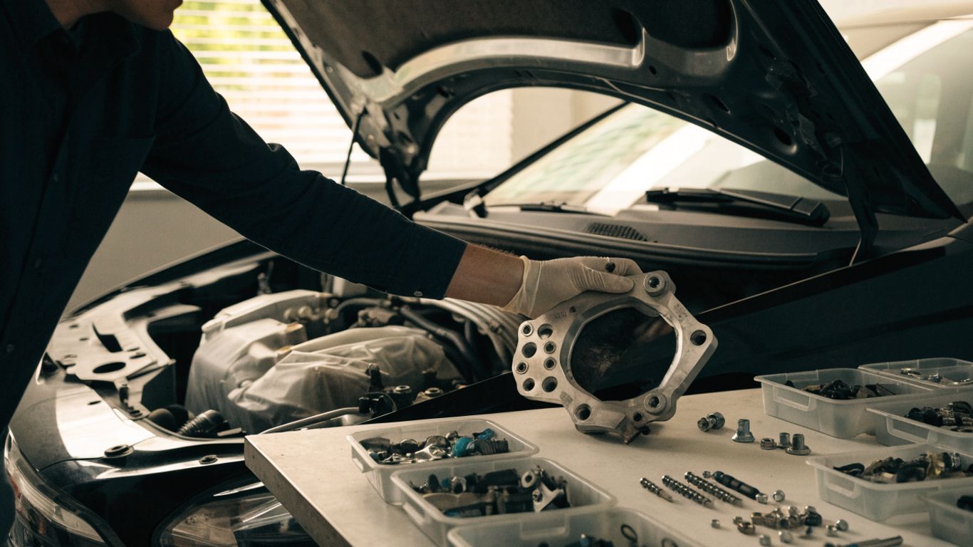 Technician organizing removed engine components on a workbench