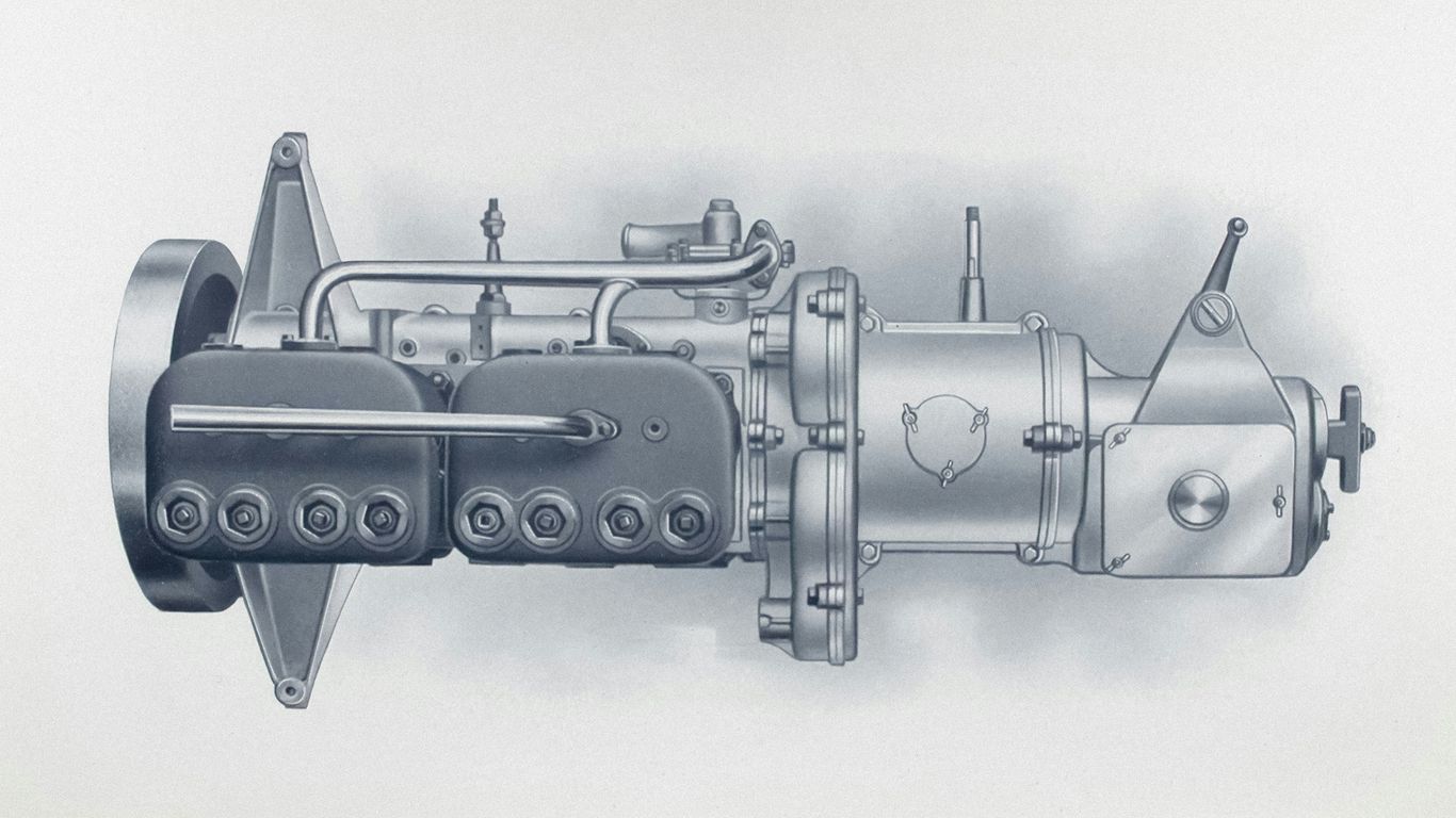 A vintage engine with two cylinders and a flywheel.