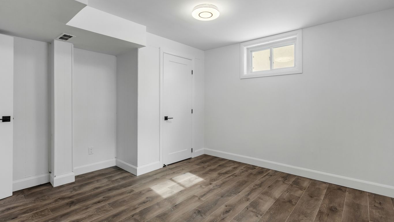 an empty room with white walls and wooden floors