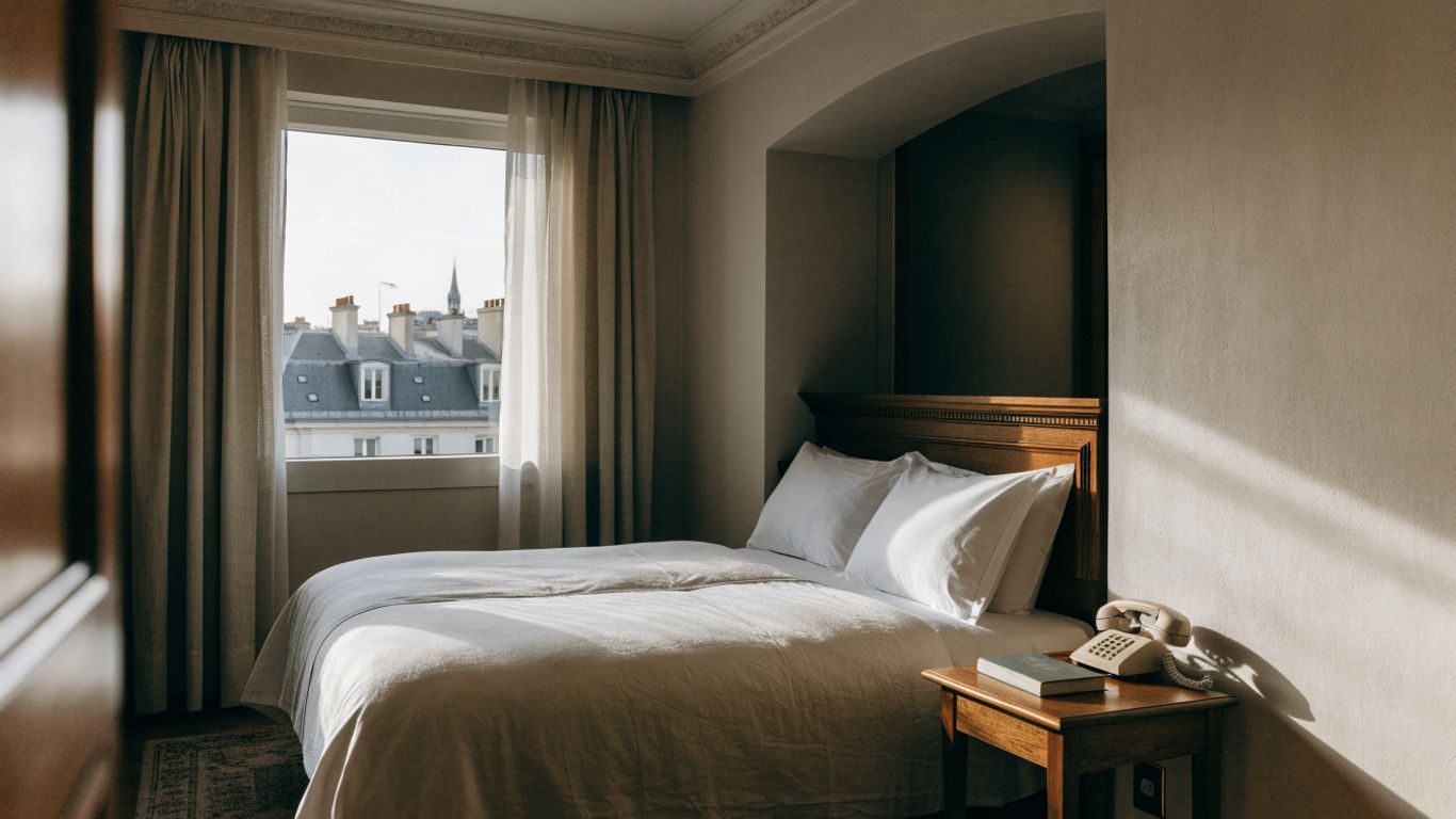 A small Paris hotel room with warm natural light
