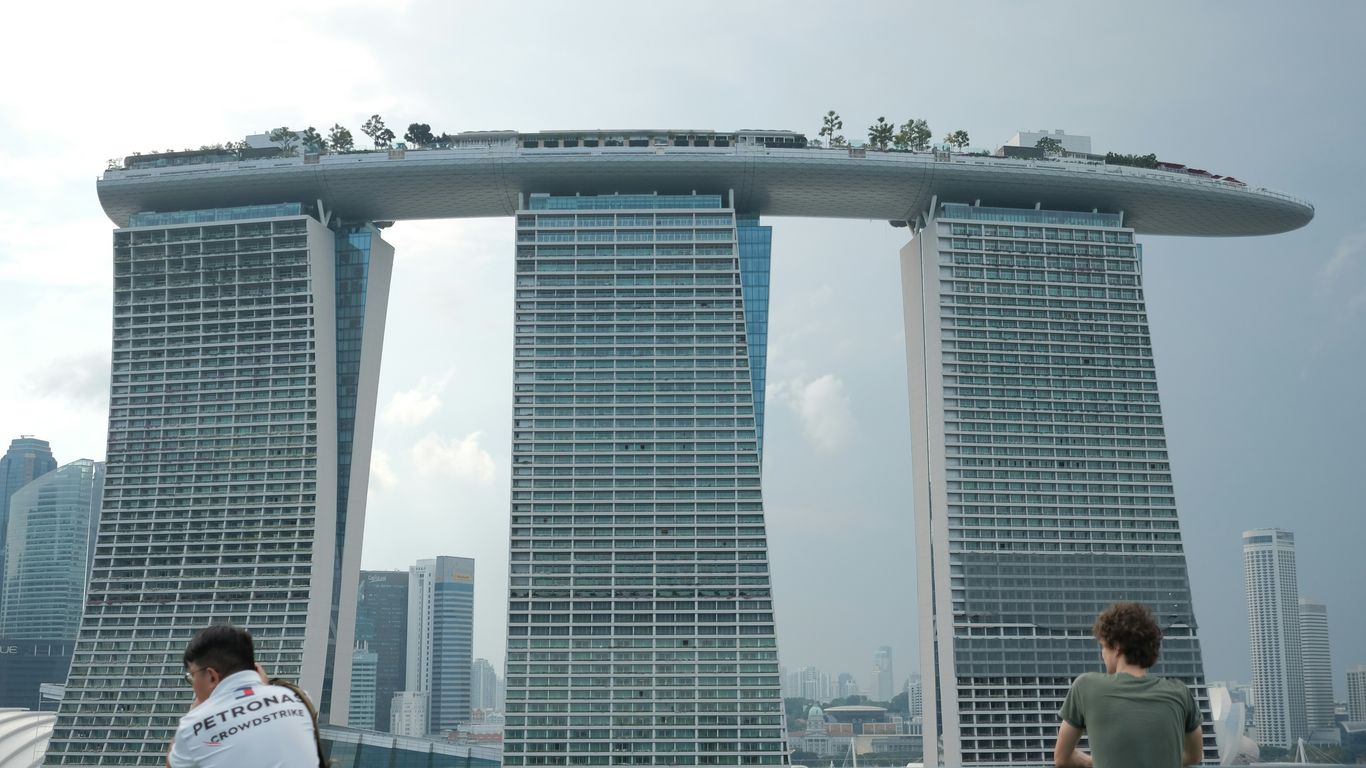 Two people overlook modern skyscrapers in a city.