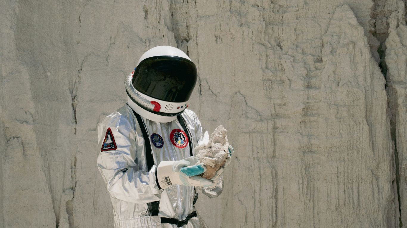 a man in a space suit holding something in his hands