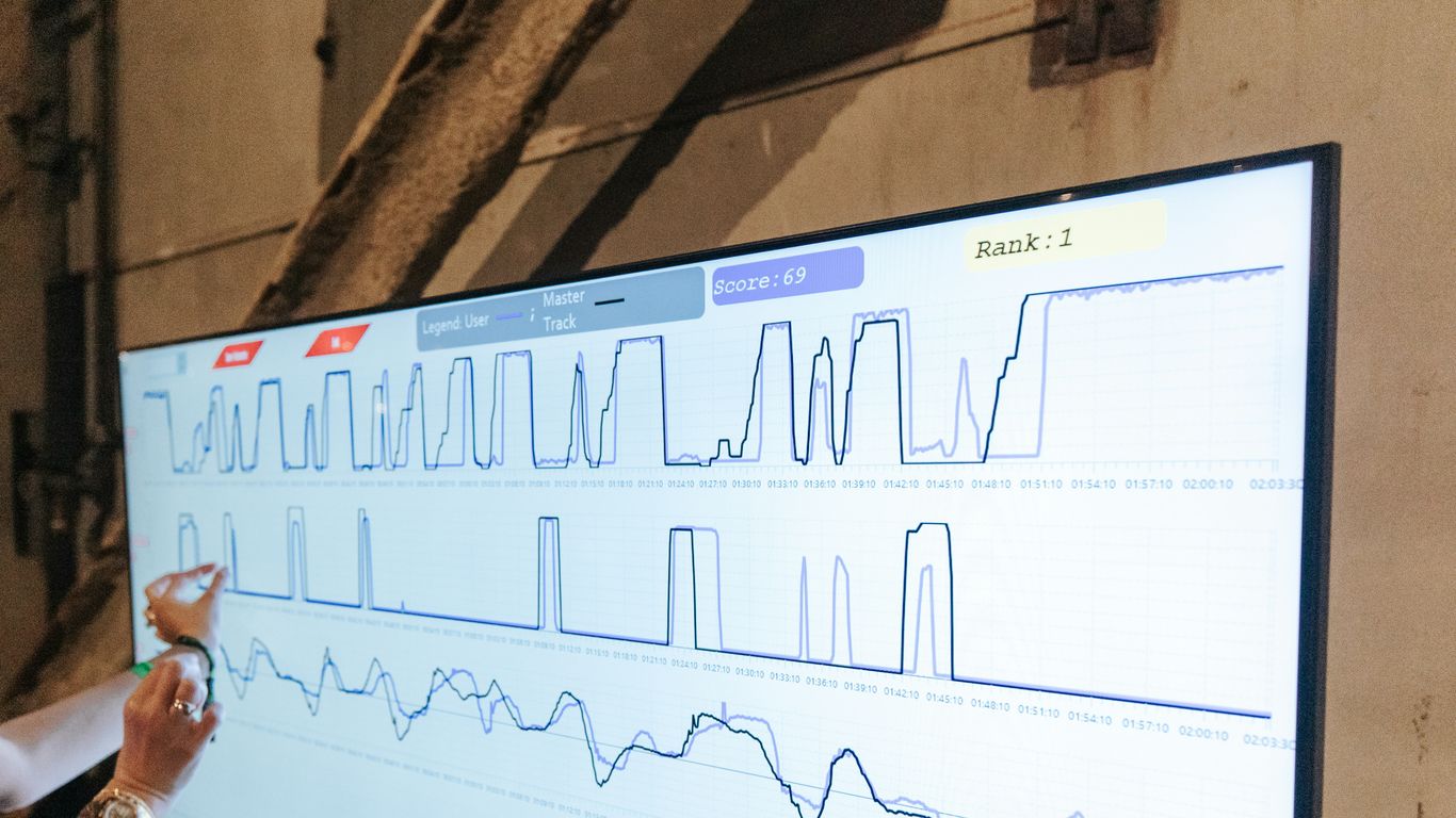 a woman points to a chart on a large screen