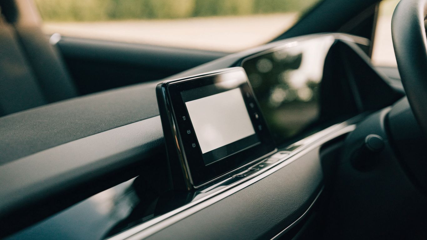 Vehicle dashboard displaying an infotainment interface in a parked car