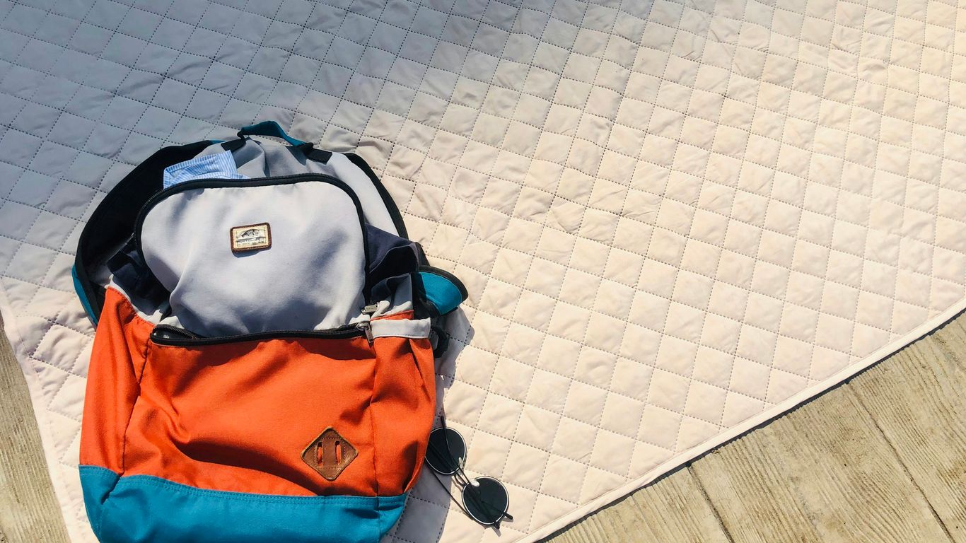 Foldable yoga mat beside travel bag