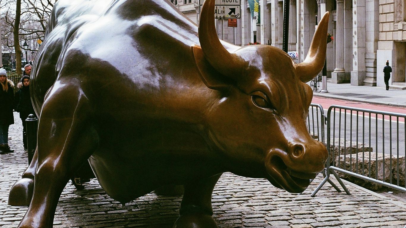 A statue of a bull on a city street