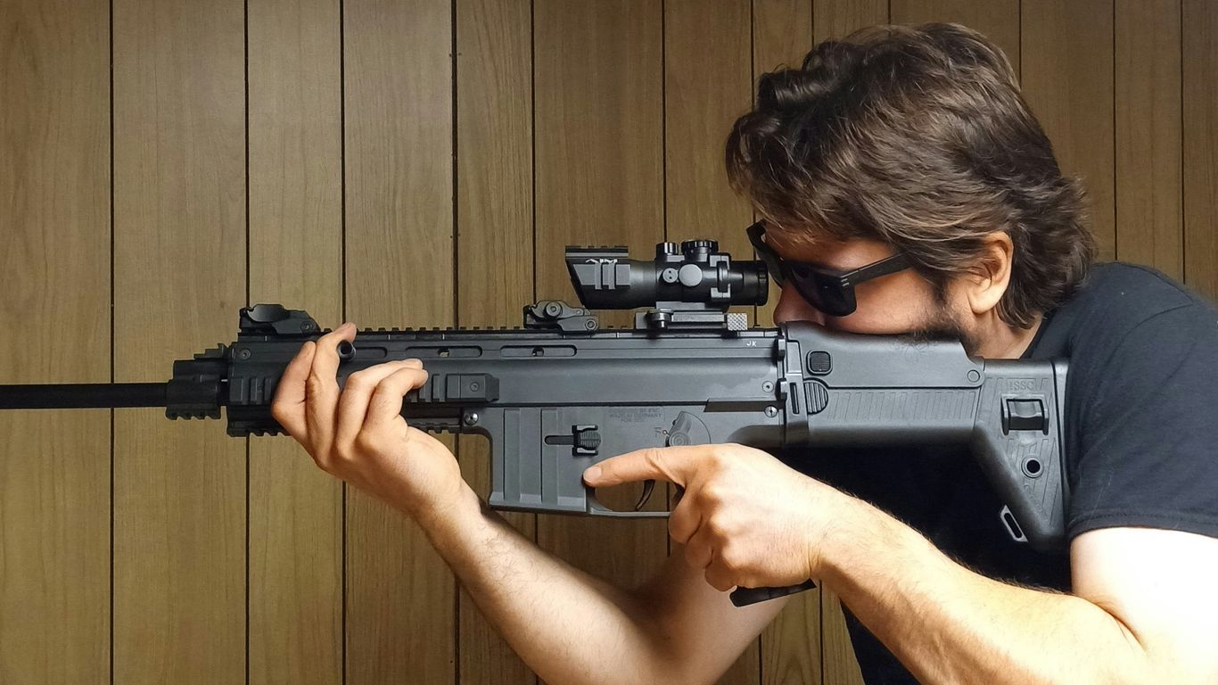 A man holding a rifle in his right hand