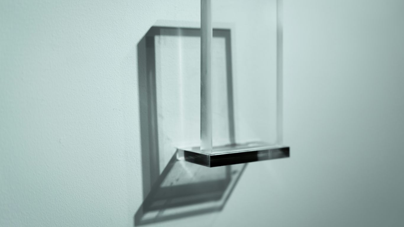 Modern glass shelf mounted on a light blue wall