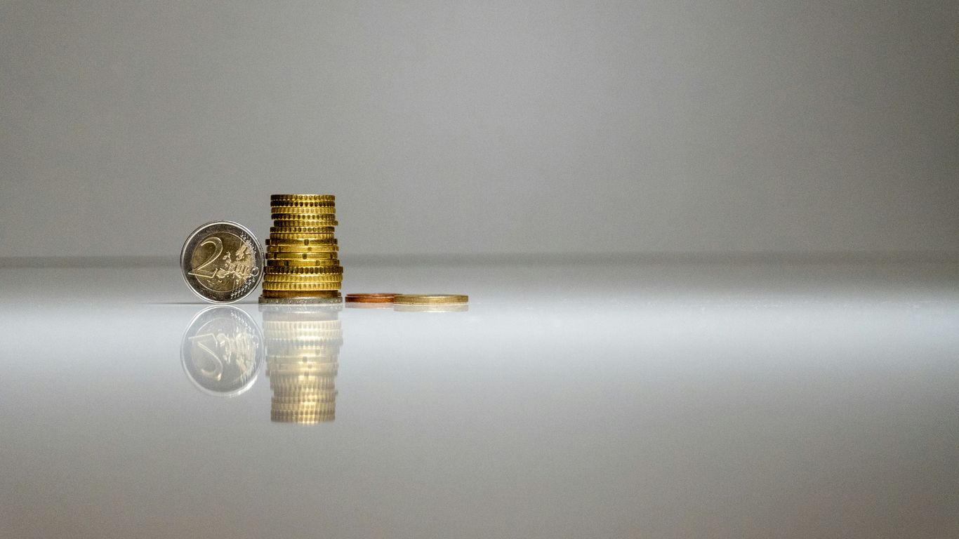 a stack of coins sitting on top of a reflective surface