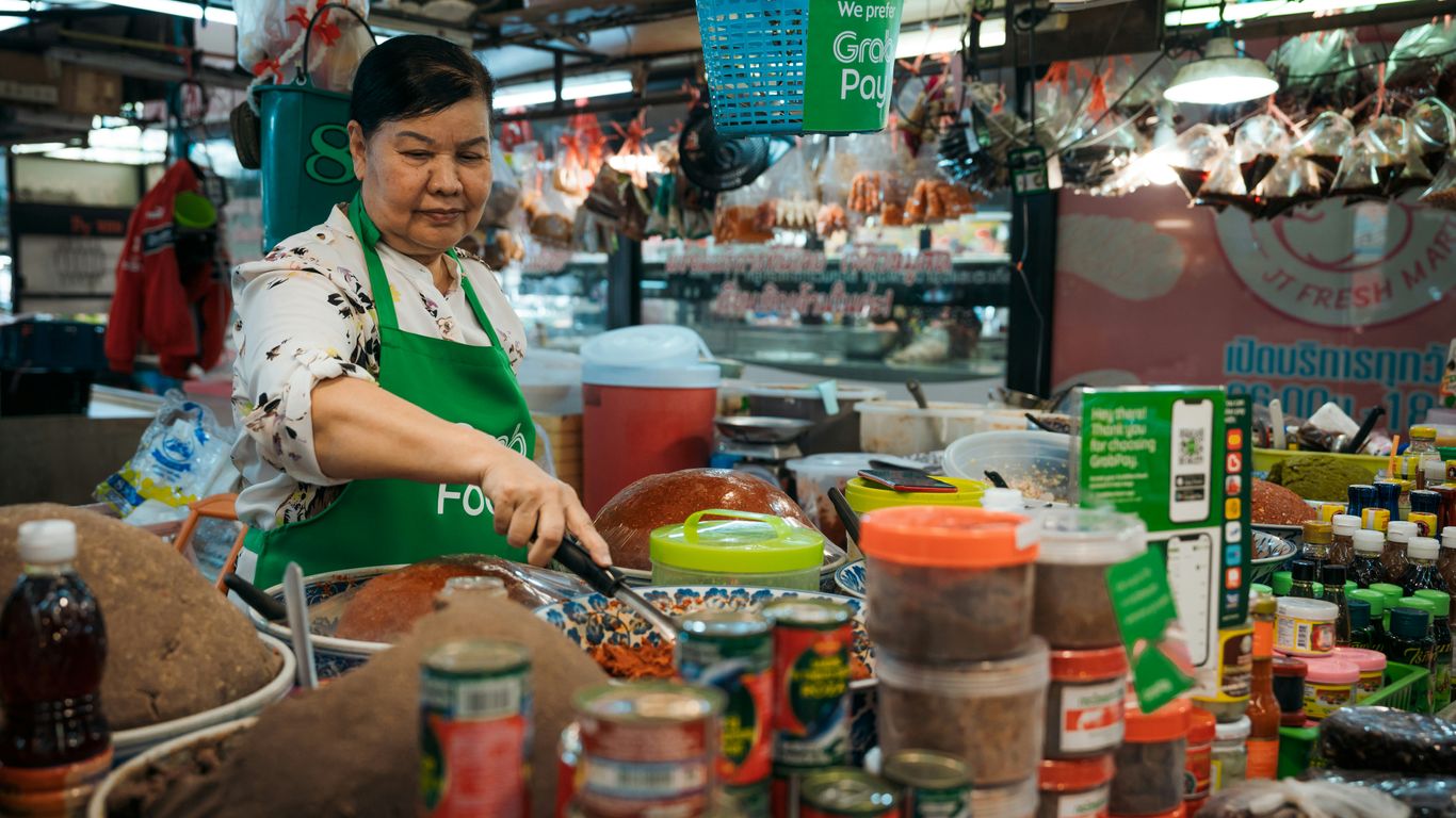 a woman in a green apron cooking in a kitchen