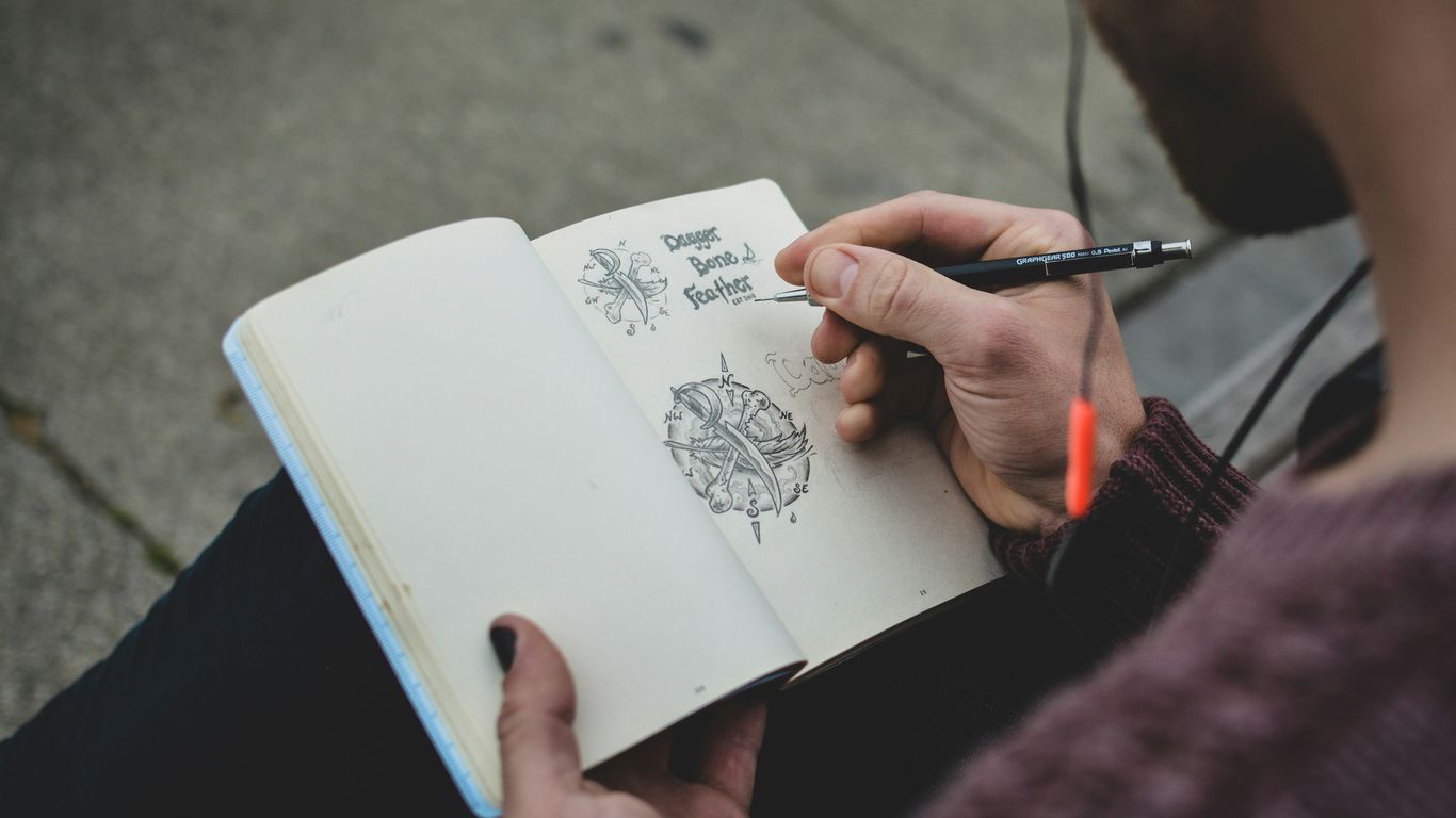 shallow focus photography of person drawing