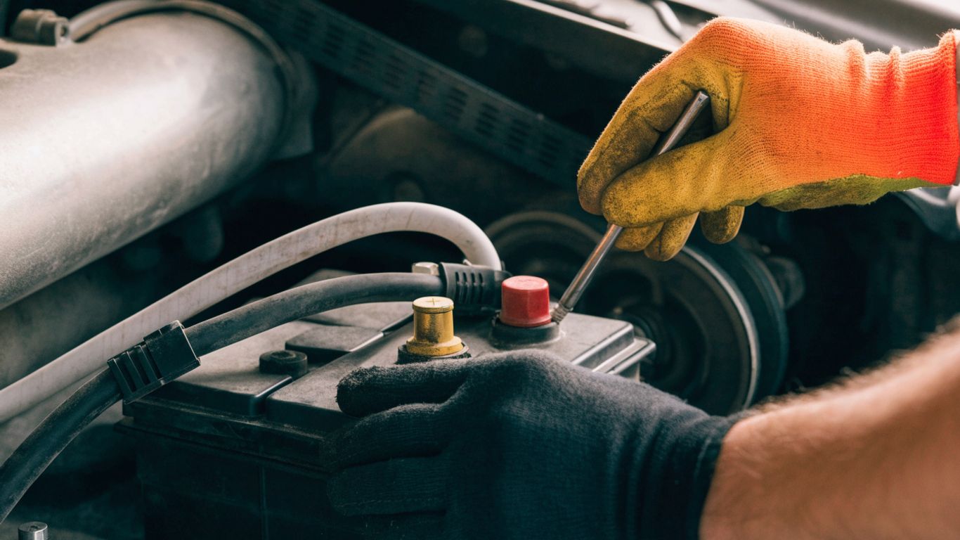 Technician inspecting a vehicle battery and cables