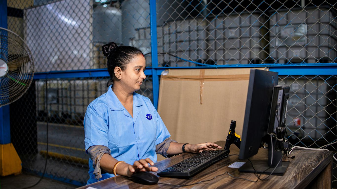 Woman works on a computer in a warehouse.