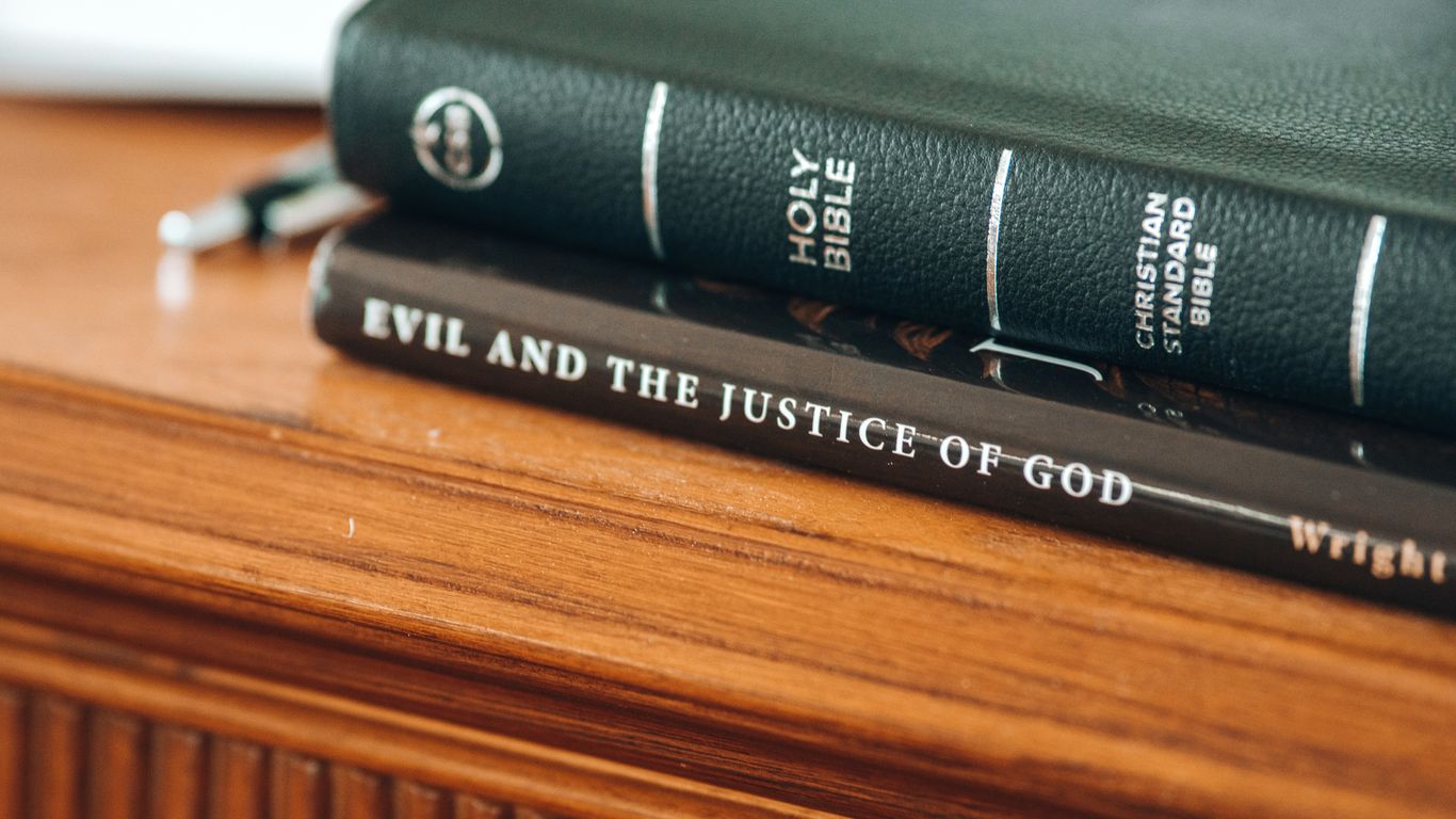 four books on brown wooden table