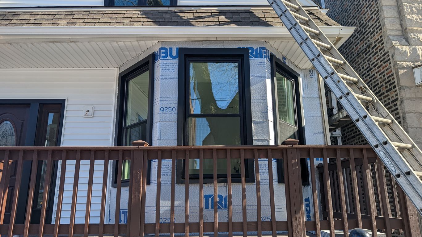 House exterior with new windows and siding under construction.