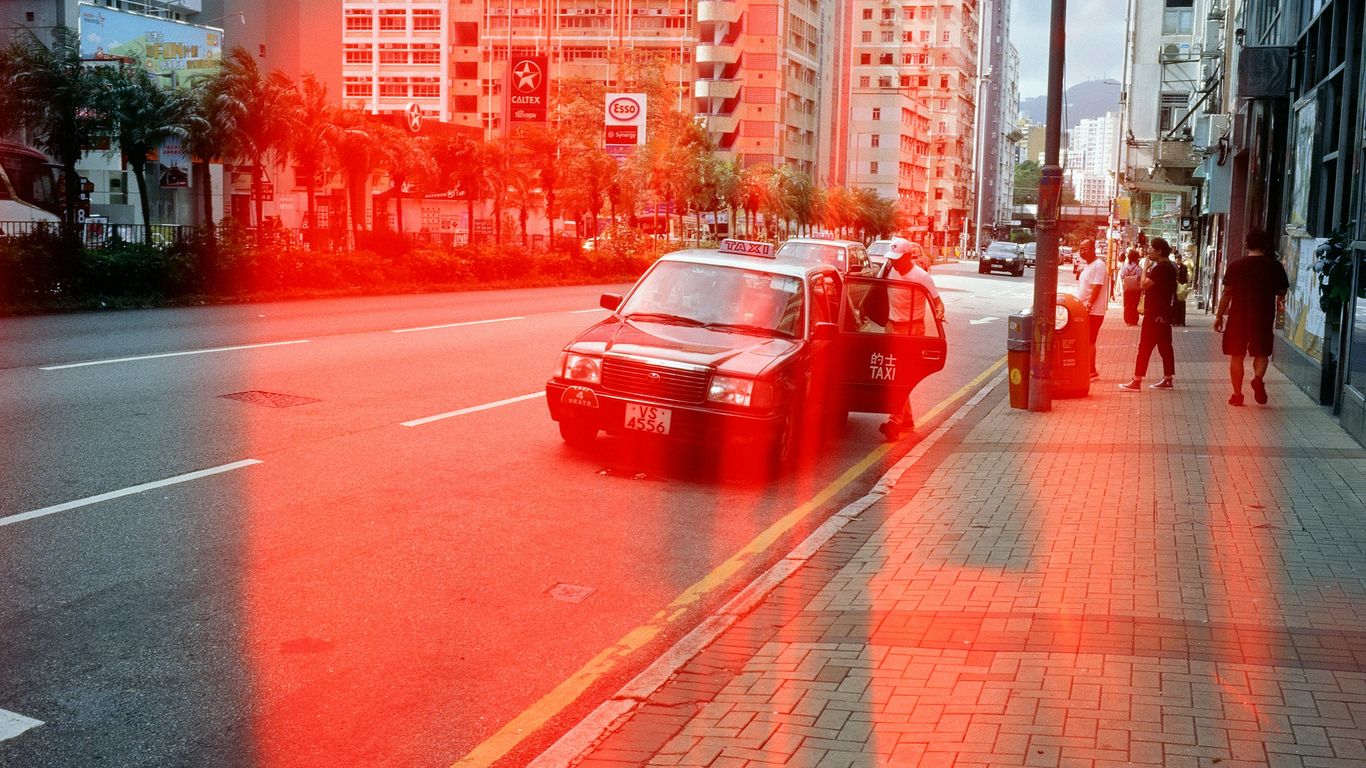 Red light flare over a city street with taxi.