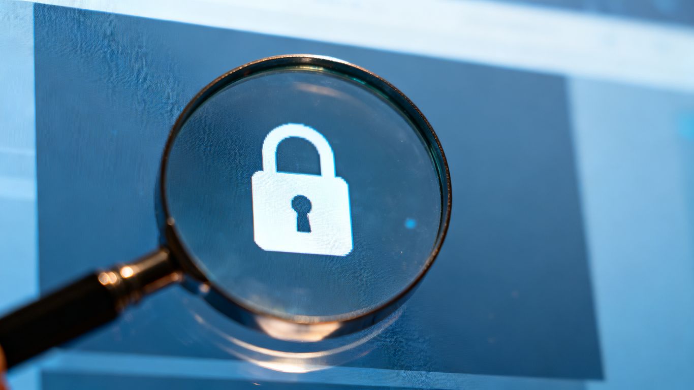 Magnifying glass over padlock on a computer screen.