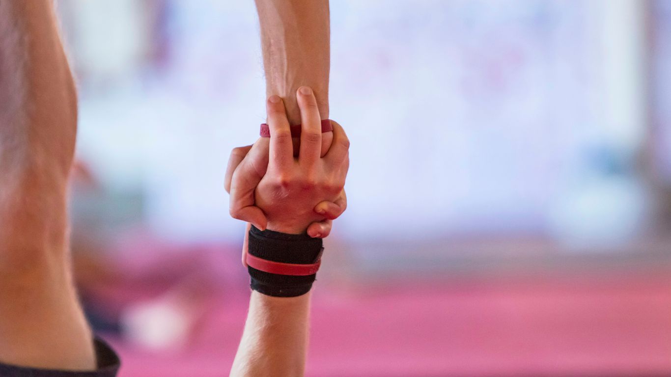 a close up of two people holding hands