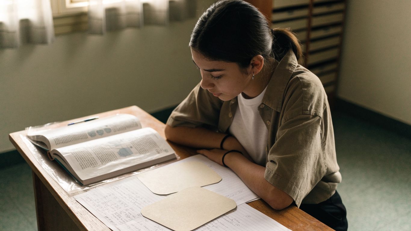 Estudiante repasando apuntes y tarjetas de estudio