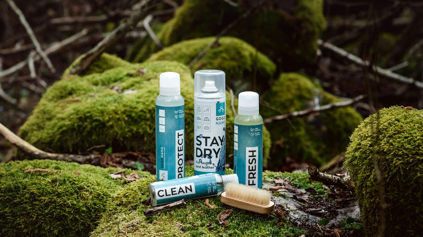 a couple of bottles of deodorant sitting on top of a moss covered