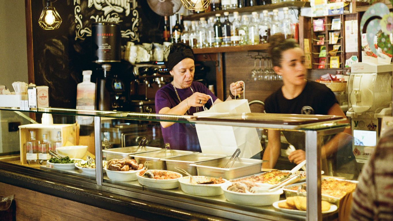 A stallholder serving customers at dawn