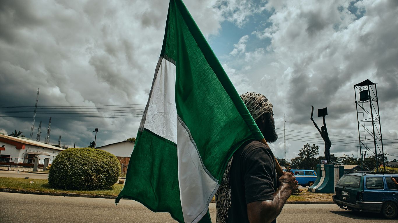 woman in black and white hijab holding green flag