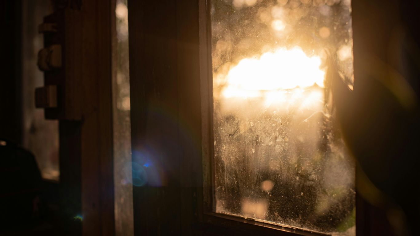 the sun is shining through a window on a rainy day