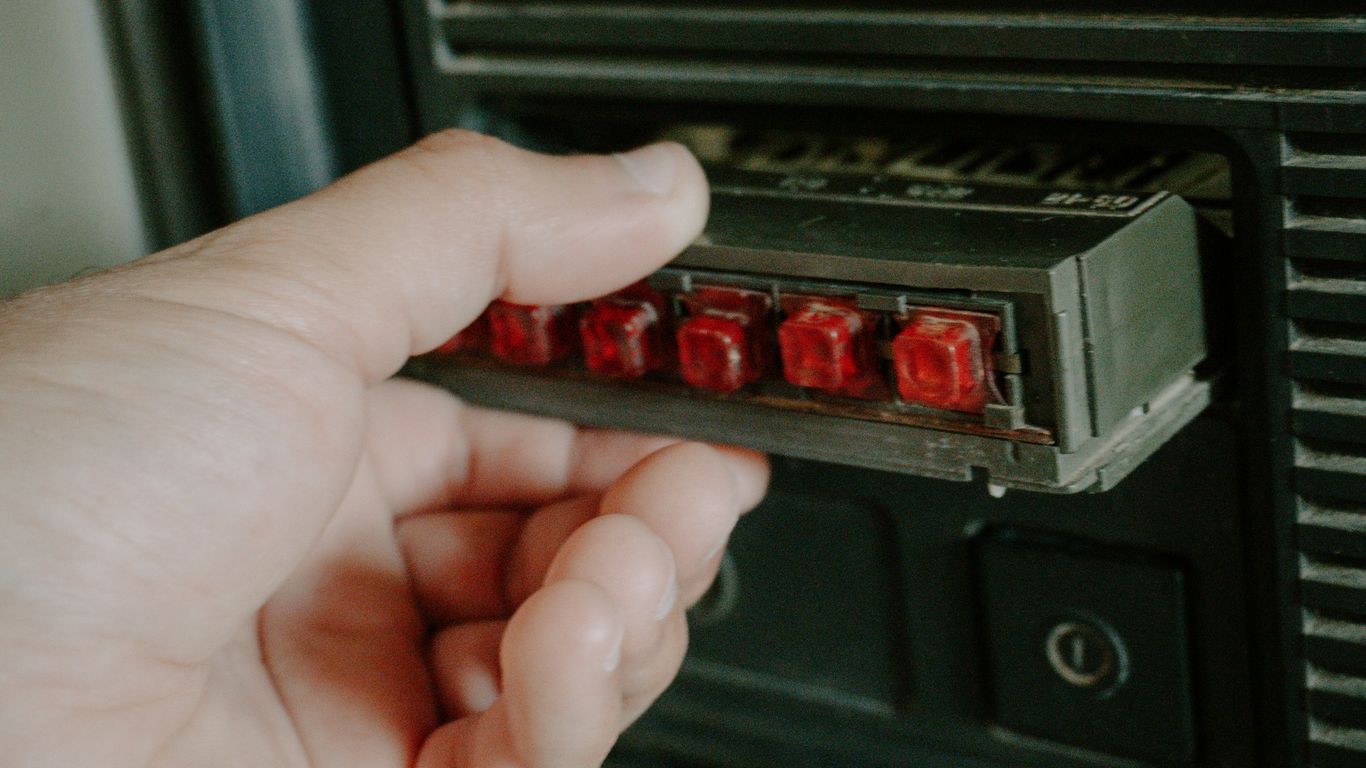 Hand inserts red-lit component into device.