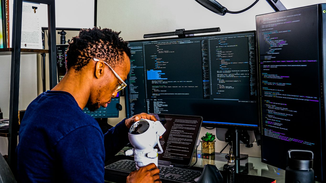 a man is looking through a microscope at a computer