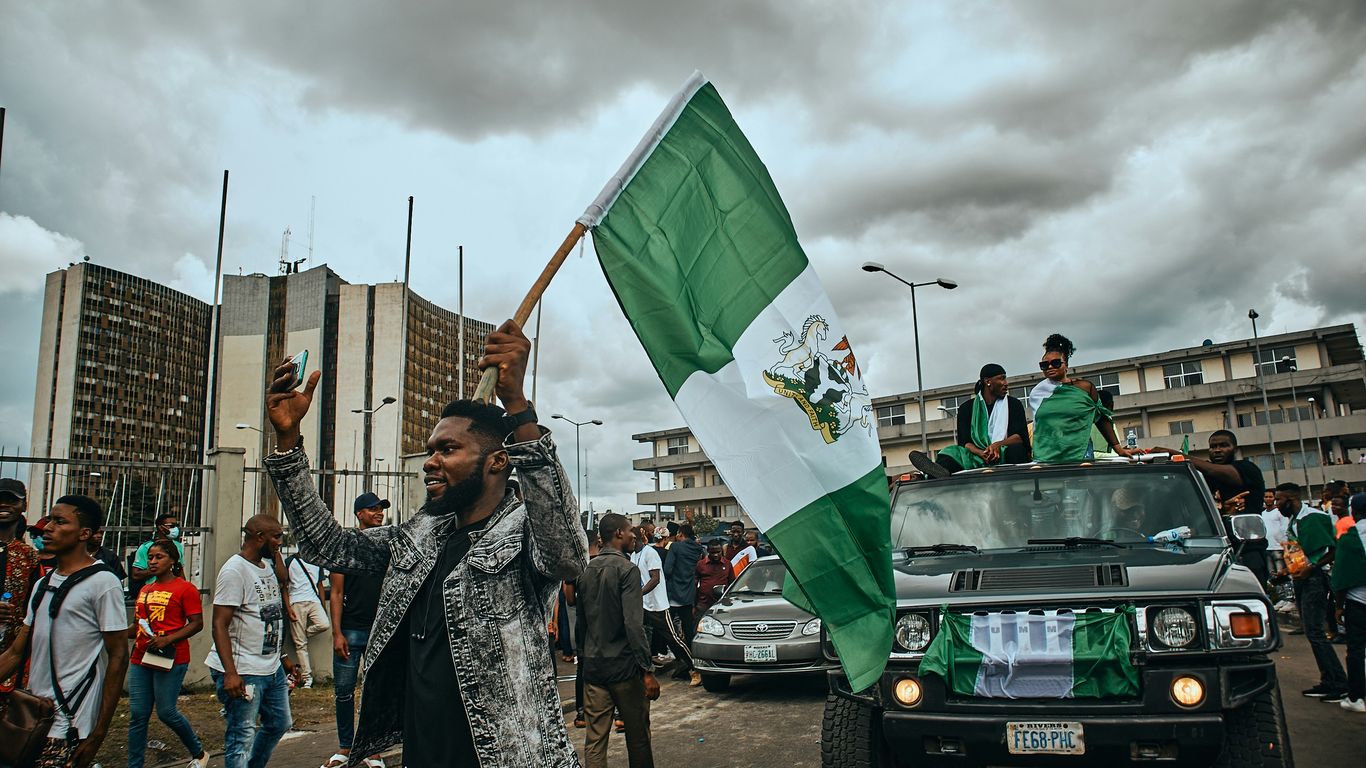 a group of people walking down a street holding a flag
