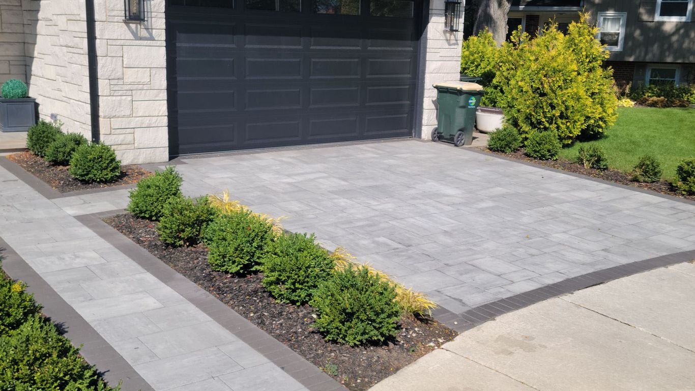 Modern house with a gray paver driveway and walkway.