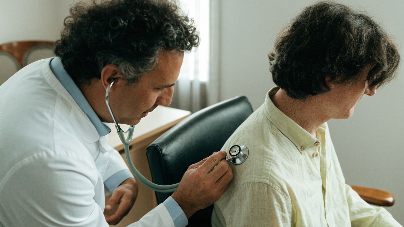 Médecin auscultant calmement la poitrine d’un patient