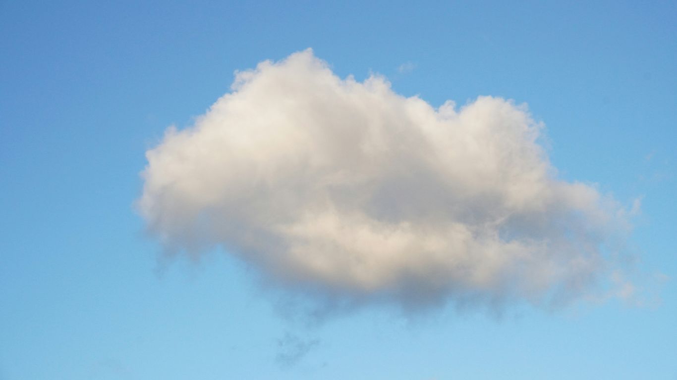 A single fluffy cloud against a clear blue sky.