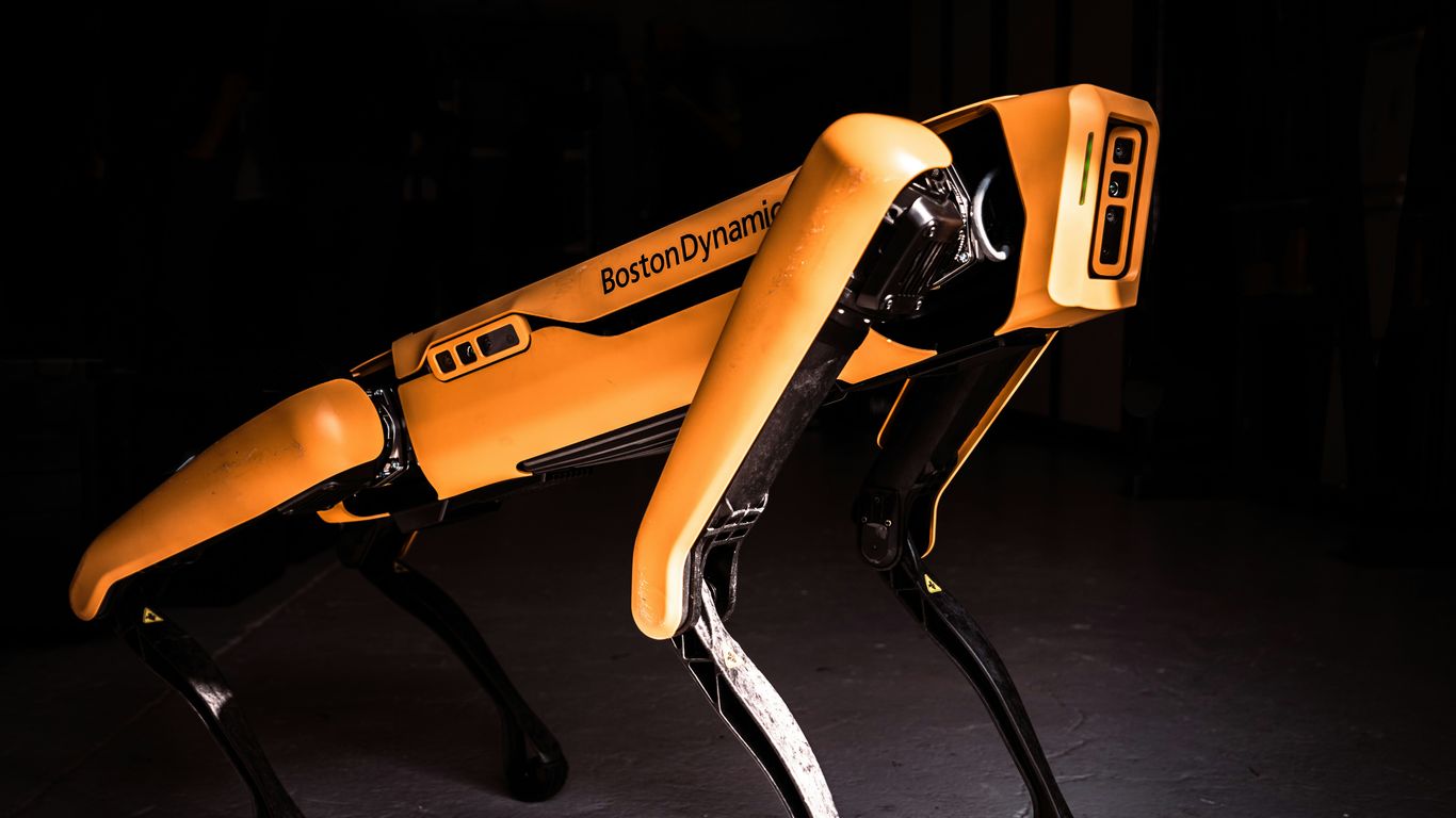 A bipedal robot walks on a smooth surface.